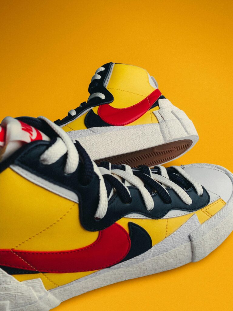 High-top sneakers with vibrant colors on a striking yellow backdrop.